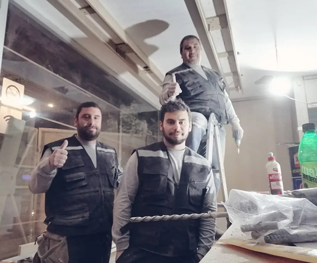 Tres integrantes del equipo Gutber con chalecos de trabajo, levantando el pulgar en la obra